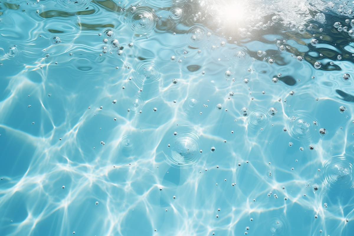 A close-up of clear pool water with tiny bubbles